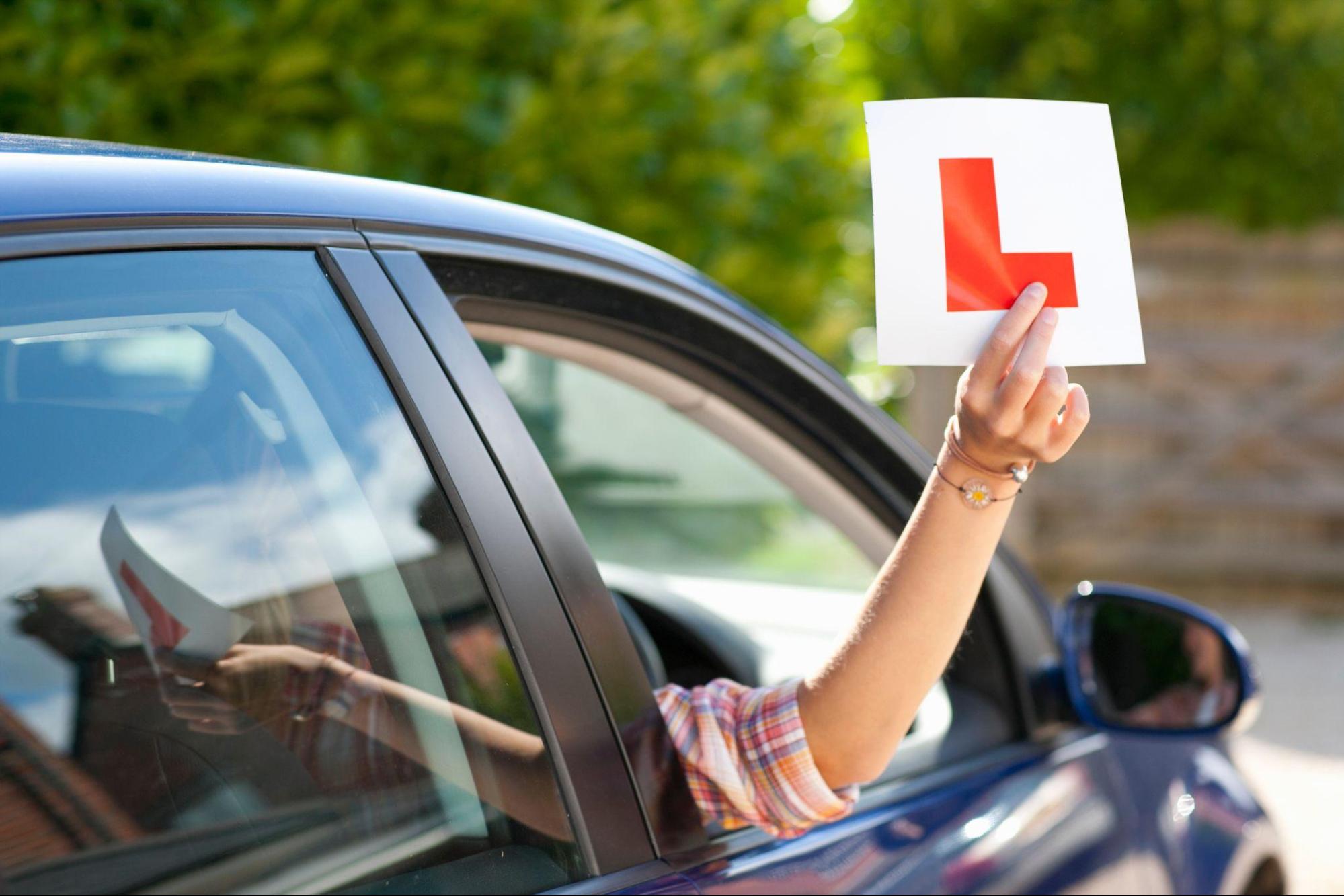 learner-driver-holding-sign